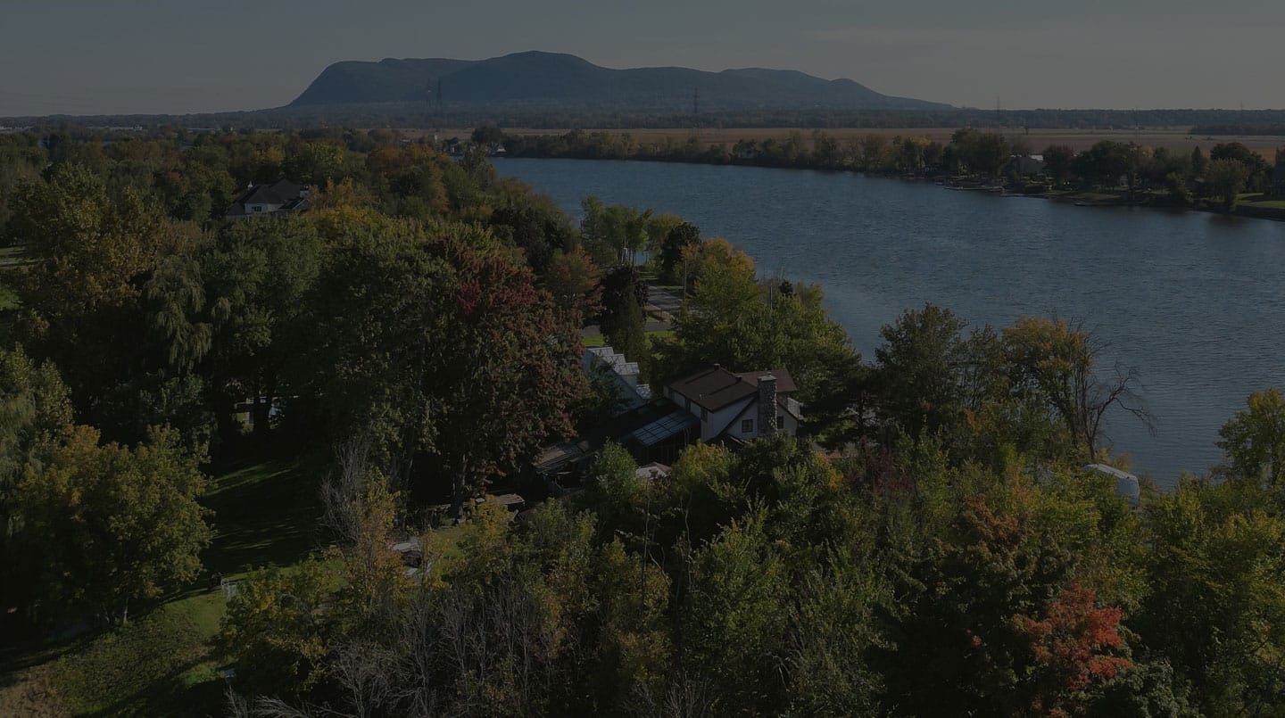 Vu aerienne d'une maison en bord de riviere a beloeil.